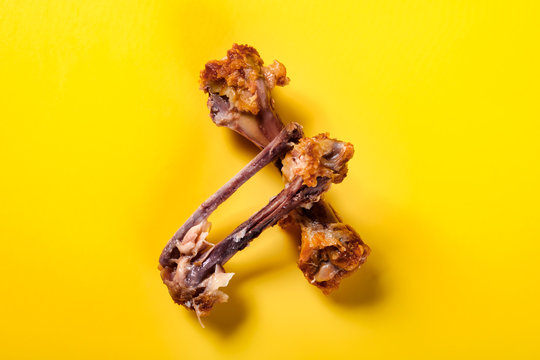 top view bones of deep fried chicken drumstick and wing on yellow background
