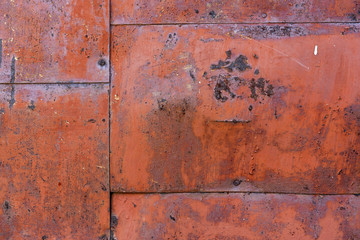 old iron wall consisting of separate pieces of metal. metal patches. Metal sheets from which the area is paint. Iron rusting.