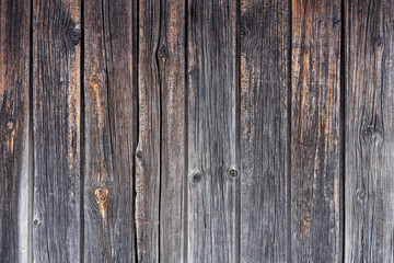 old wooden fence. Faded wooden planks with corrosion. Peeled wooden door of several boards. Old natural wooden board without paint.