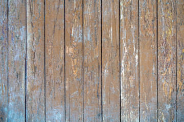 Obraz premium old painted wooden planks of yellow color are peeling off from time. Paint peeling off the wooden surface of the old planks. Texture of old painted wooden boards