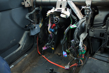 disassembled car interior with wires and steering rack