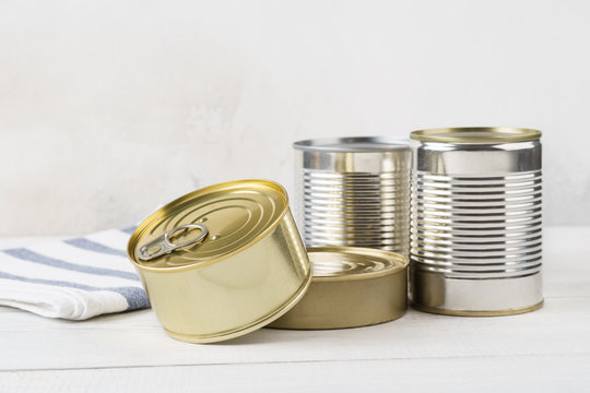 Various closed tin cans with food preserves.