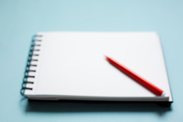 Red pen on a blank white notebook with old wooden background