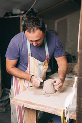 Man creating pottery in his studio