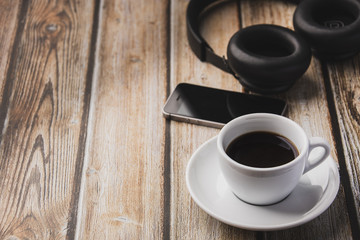 cup of coffee, headphones and mobile phones  on wooden table