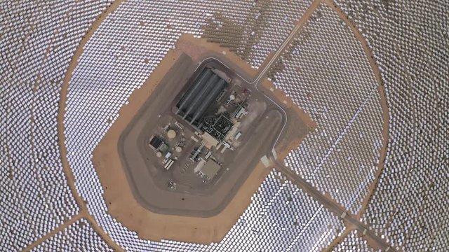 Drone rotates on its axis showing view on circles of solar panels and power station in the middle. Aerial 4K