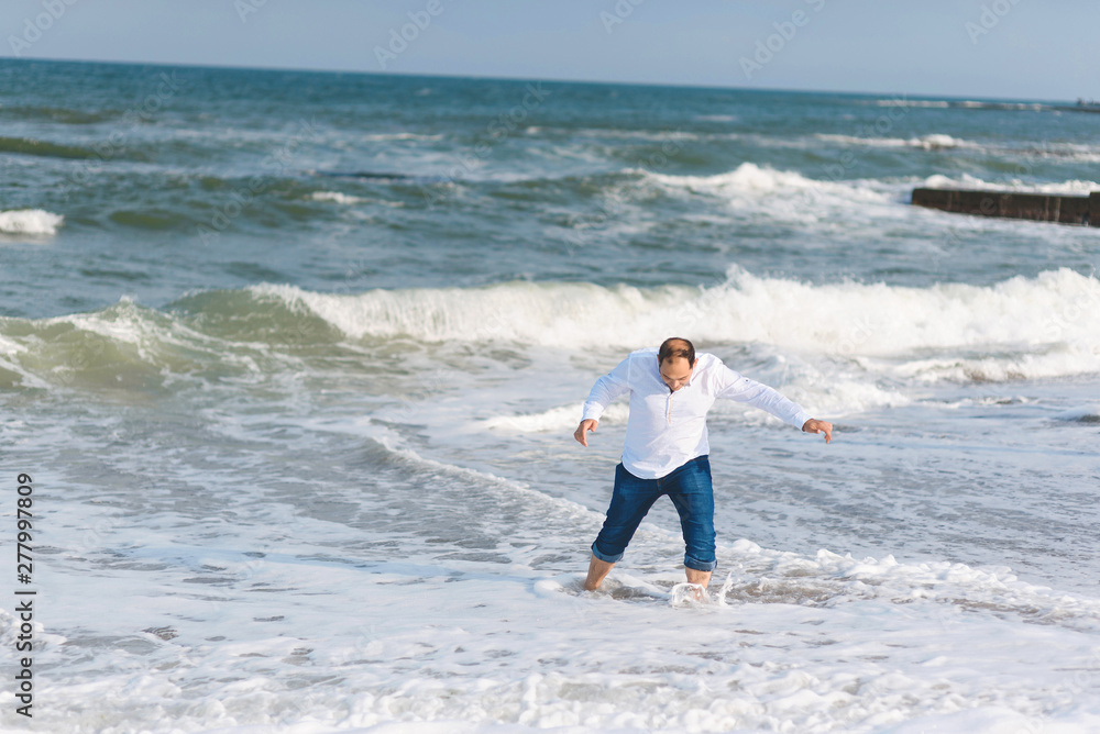 Wall mural man having fun in sea waves