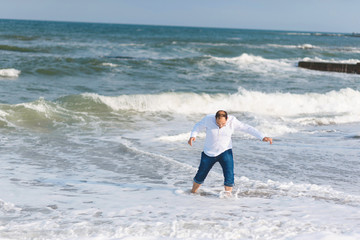 Fototapeta na wymiar man having fun in sea waves