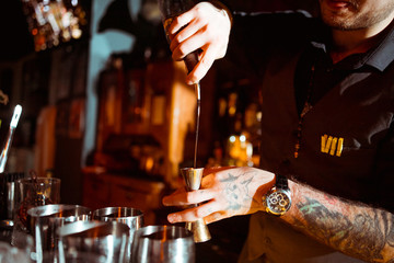 Expert barman is making cocktail at night club