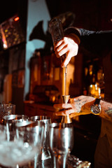 Expert barman is making cocktail at night club