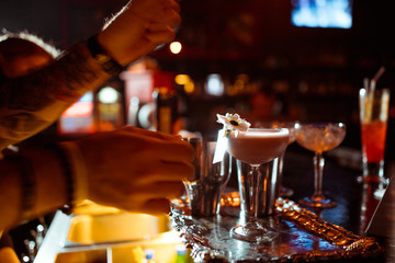 Expert barman is making cocktail at night club