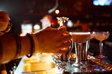 Expert barman is making cocktail at night club