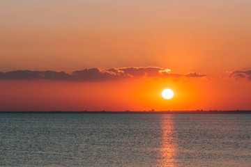 Fototapeta na wymiar Bright, summer sunset over the sea surface .