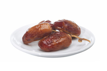 Dried date palm are shiny in ceramic dish isolated on white background.