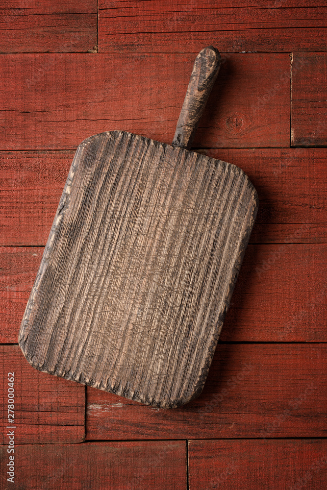 Wall mural Old cutting board on wooden table. Food background