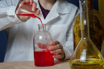 Lab female medical or scientific laboratory researcher performs tests with red liquid. Close up