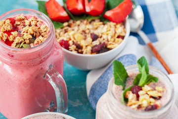 Bowl of homemade granola with yogurt and fresh berries on wooden background