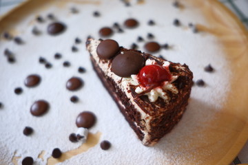 Close up a half piece of chocolate cake in a wooden dish on the table.