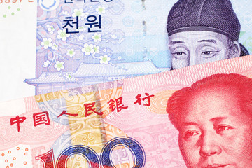 A blue two thousand won note from South Korea close up in macro with a red, one hundred yuan note from the People's Republic of China