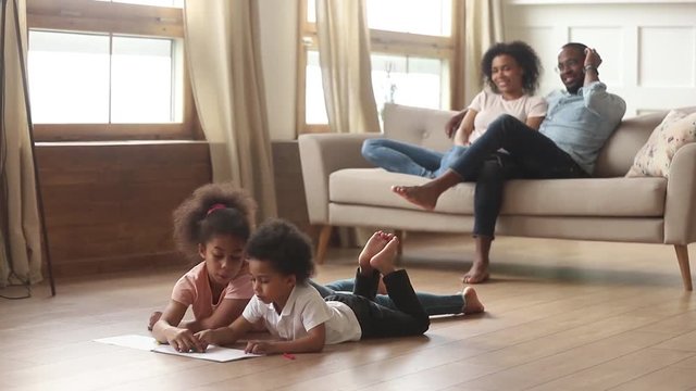 Happy african family with kids in living room leisure activities