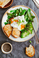 Top view of healthy breakfast or lunch. Fried snow peas, avocado, poached eggs are sprinkled chia seeds with toasts.