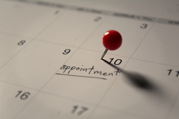 Close up red pin on calendar, event and planing concept.