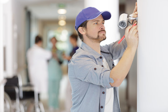 contractor installing a cctv camera in a hospital