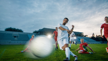 Professional Soccer Player Outruns Members of Opposing Team and Kicks Ball to Score Goal. Soccer Championship on a Stadium. Blurred Motion Shot of a Flying Ball.
