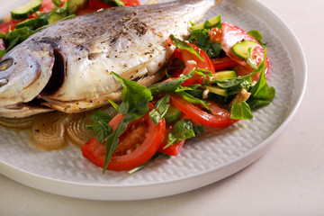 Baked dorado fish served with salad