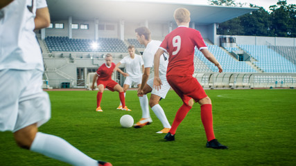 Shot of Professional Soccer Player Leads with a Ball, Masterfully Dribbling and Bypassing Sliding Tackles of His Opponents. Two Professional Teams are Playing Football Championship.