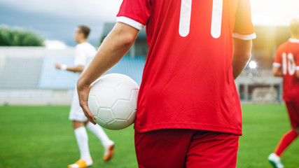 Shot of a Soccer Player Carrying Ball while Walking through the Field. In the Background...
