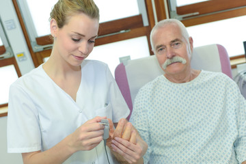 Fototapeta premium nurse putting pulse reader on to patients finger