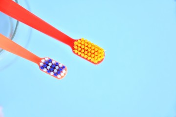 Two bright toothbrushes with soft focus on blurred blue background. Plastic toothbrush for personal daily oral hygiene. Dental healthcare. Tools for morning routine. Caries protection