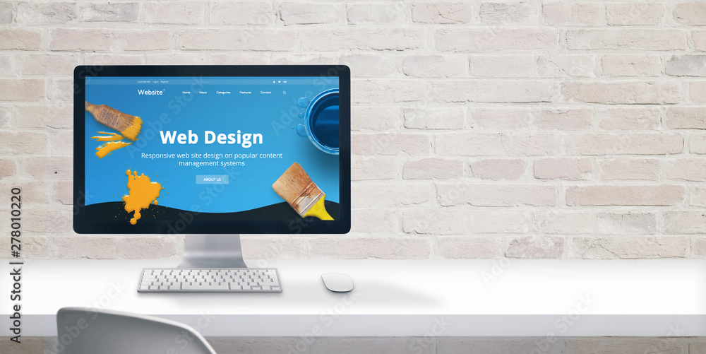 Leinwandbilder Clean web designer desk with computer display and modern flat design web site teme with web design text. Copy space beside on brick wall.