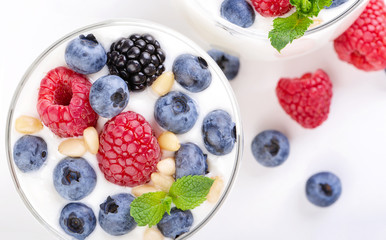 Two glasses of white yogurt with wild berries