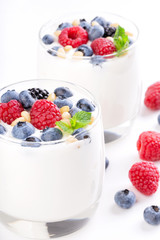 Two glasses of white yogurt with wild berries