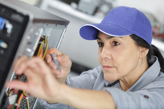 female pc technician soldering a chip from a desktop computer