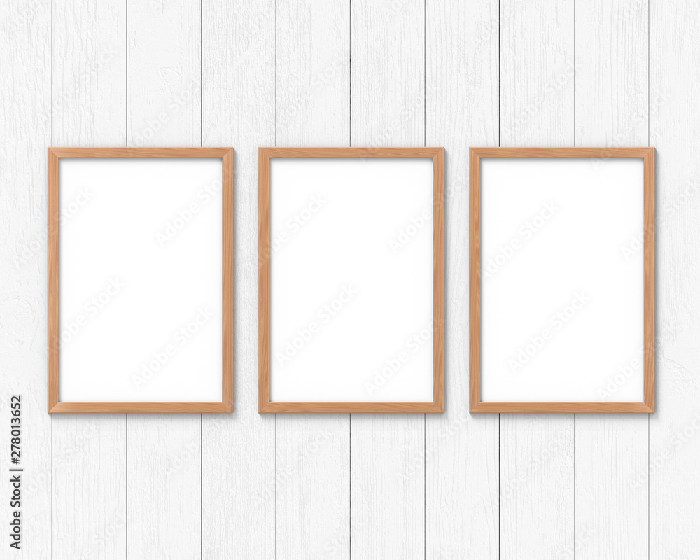 Fototapete set of 3 vertical wooden frames mockup with a border hanging on the wall. empty base for picture or 