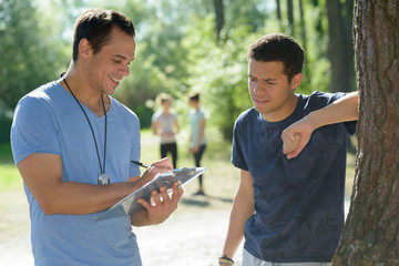 handsome personal trainer with runner outdoors