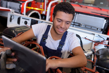 Naklejka premium mechanic with digital tablet while examining vehicule
