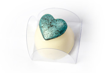 White chocolate candy stuffed with heart covered with edible blue paint as decoration.