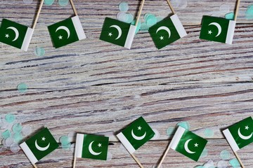 independence day of Pakistan. August 14. the concept of freedom, independence and patriotism. mini flags with confetti on wooden background. horizontal