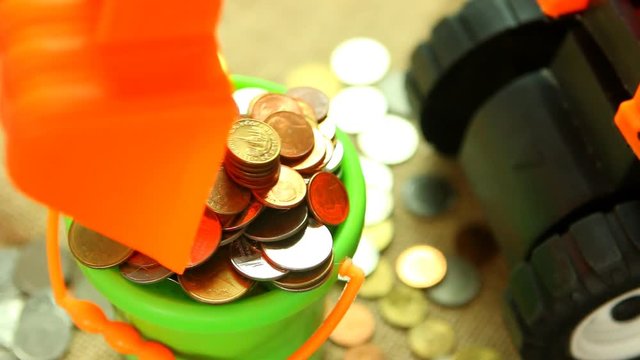 Toy backhoe  with pile of coin, in studio Chiangmai Thailand