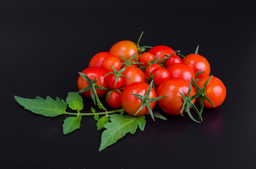 Red ripe cherry tomatoes on black background