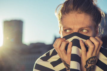 Scared young hipster man hiding his face