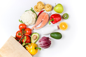 Healthy food background. Healthy food in paper bag fruits, vegetables, milk, pasta and fish on...