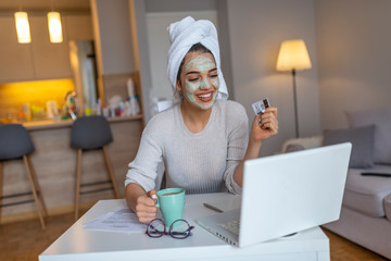 Woman with cosmetic face mask shopping online from her home. Leisure time at home. pPortrait of...