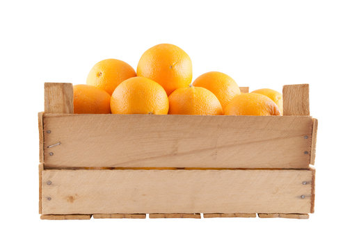Many ripe orange fruits in wooden box isolated on white