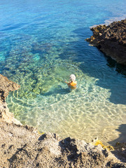 woman is swimming in the clear water of the Sardinia