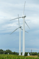 Pair of wind turbines against a sky with clouds. Clean energy for the agro farm.